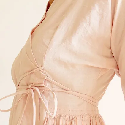 Close-up of a blush pink handwoven Khadi cotton wrap dress, showcasing sustainable fashion design and natural fabric texture