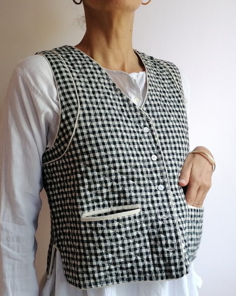 model wears reversible quilted waistcoat handwoven black gingham check