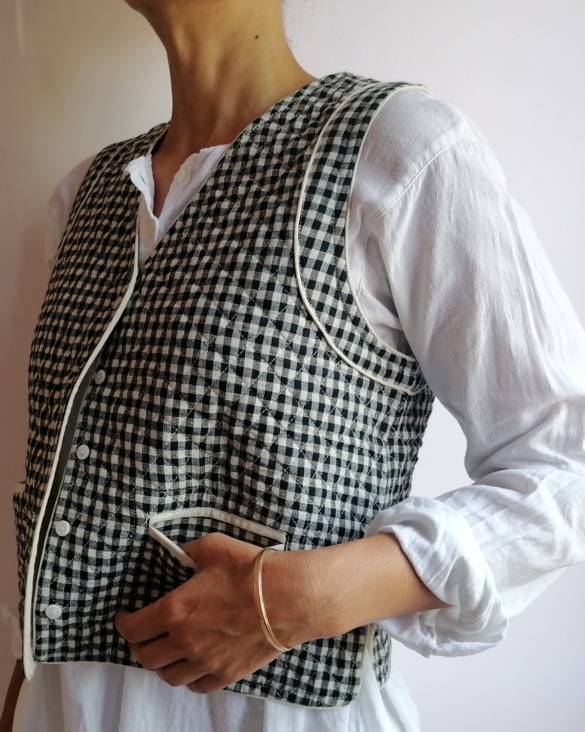 model wears reversible quilted waistcoat handwoven gingham check
